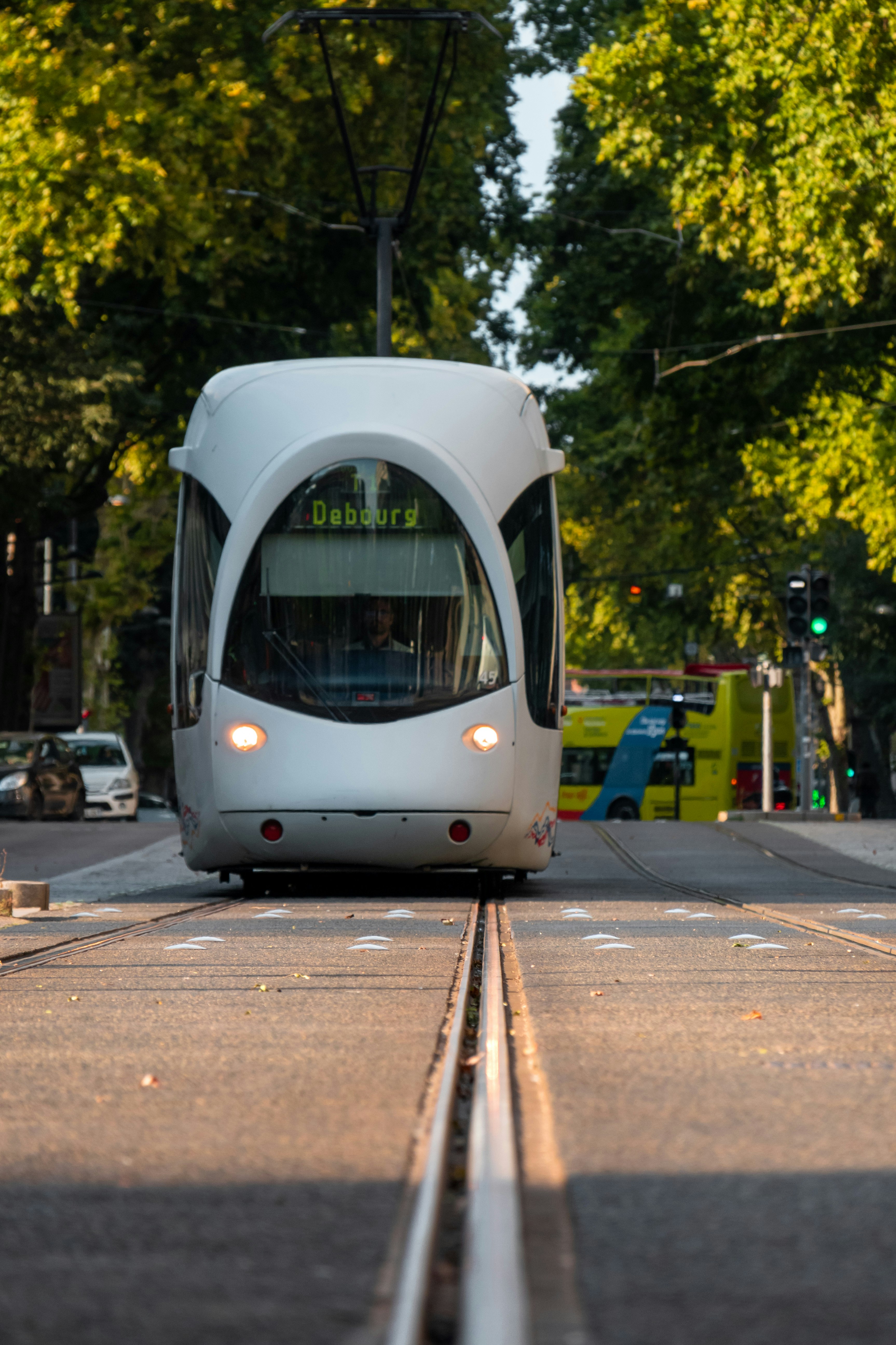 white and blue train on the street during daytime